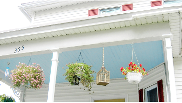 Photo of a porch ceiling painted sky blue on a two story house