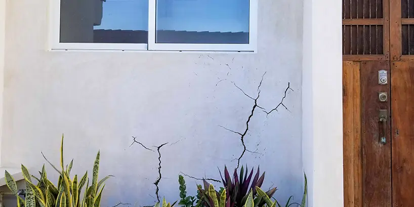 Cracked stucco with brown front door