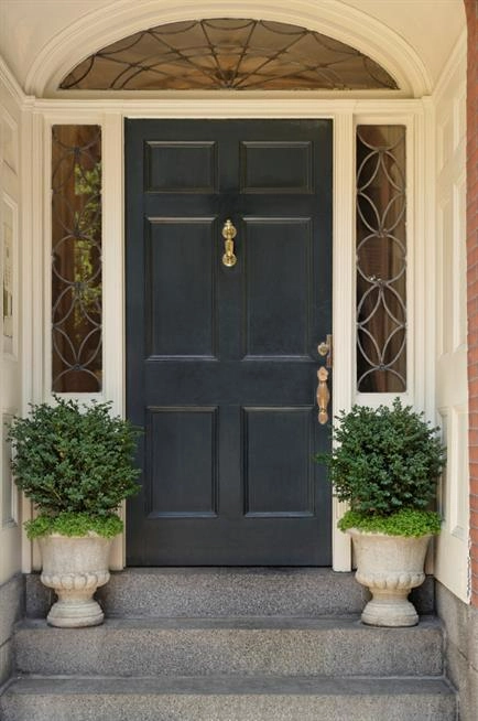 Black front door surrounded on white home   