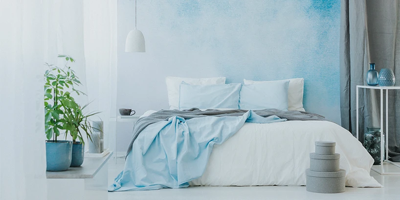 Photo of a bedroom with a blue and white accent wall