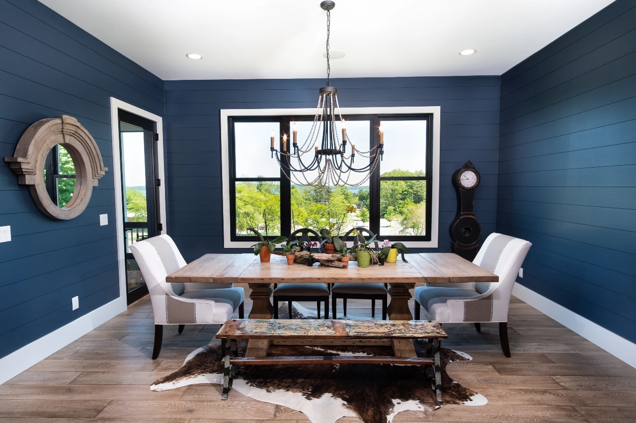 Photo of dining room with blue walls and wood table with white chairs