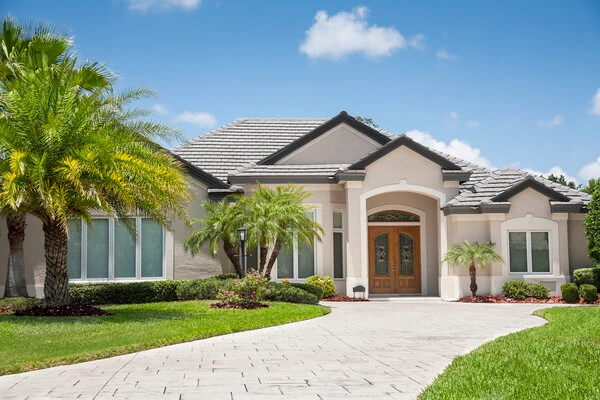 Florida house exterior with siding painted light brown and trim painted white.