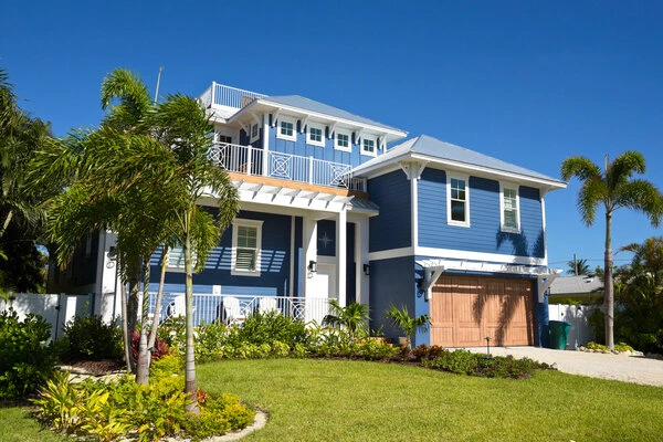 Beautiful house with exterior siding painted blue and trip painted white.