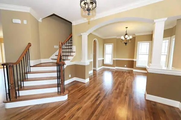 A large open foyer with hardwood floors and staircase