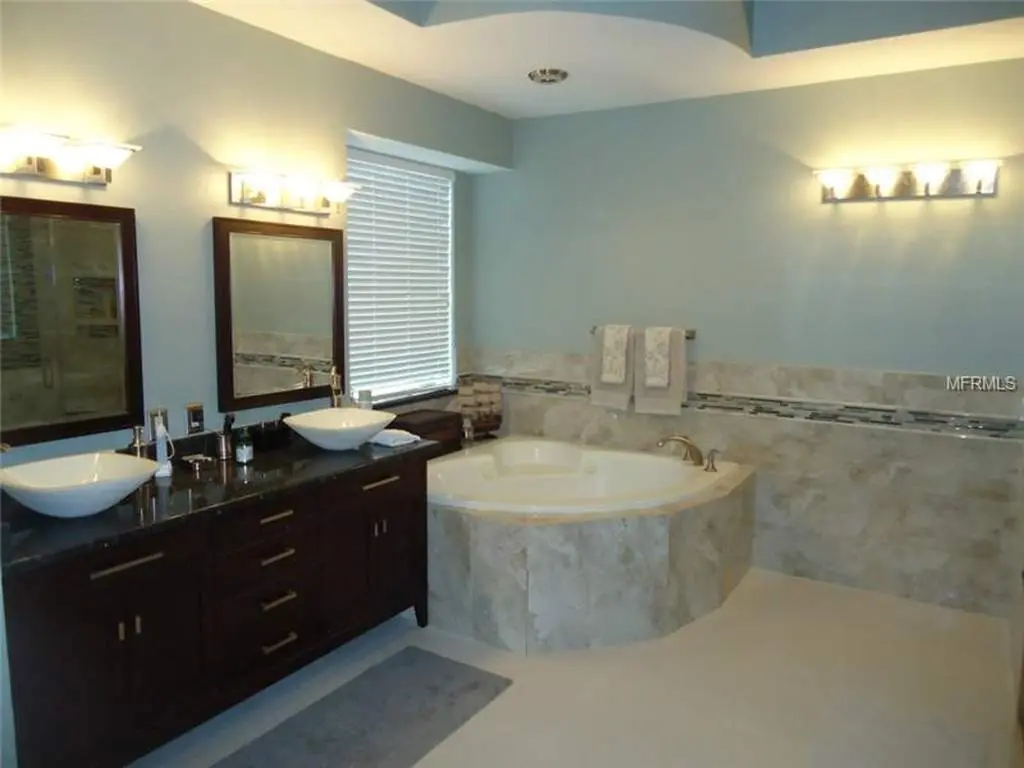 Master bath with marble tub and vanity painted in a light blue.