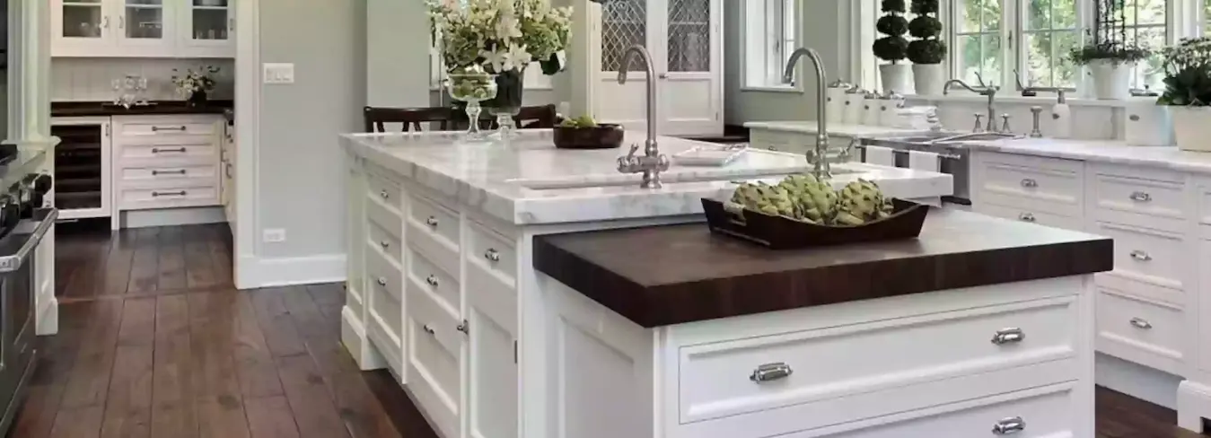 Modern, bright white kitchen with island and dark hardwood floors.