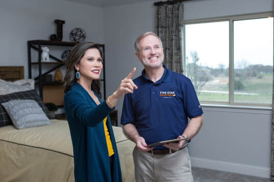 Five Star Painting estimator reviewing bedroom interior paint job with a homeowner