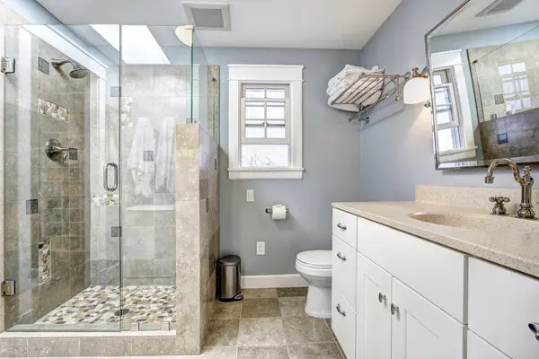 A bathroom with walk in shower painted in grey
