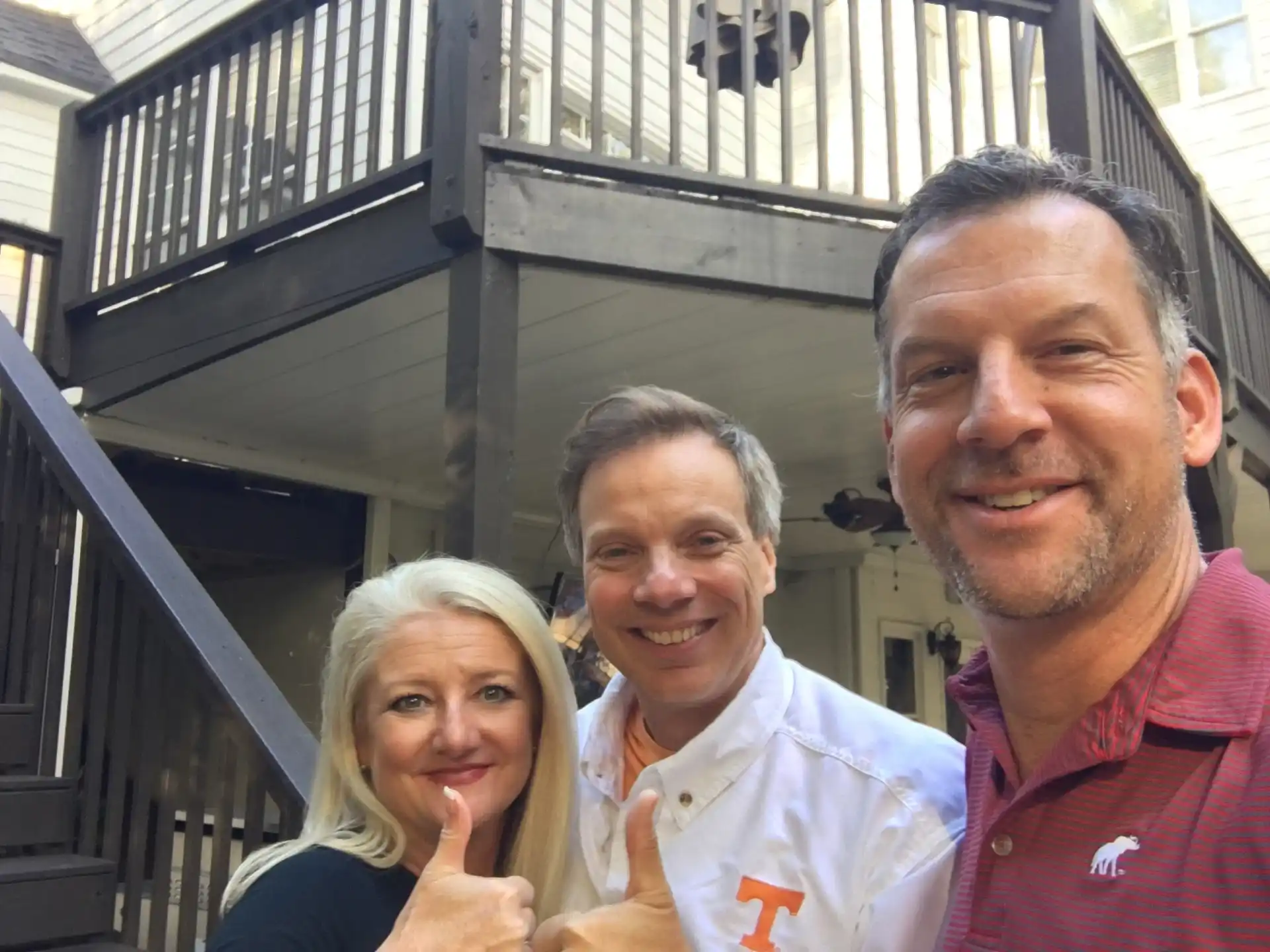 "Photo of three people taking a selfie in front of a deck"