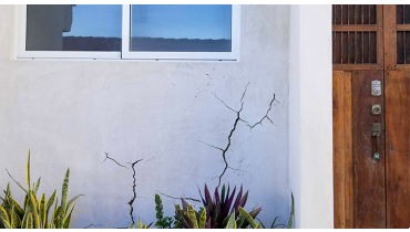 Cracked stucco with brown front door