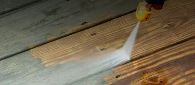 wooden deck being pressure washed