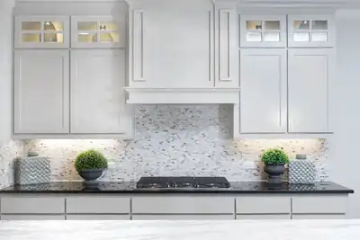 Cream cabinets over a black counter and stove top