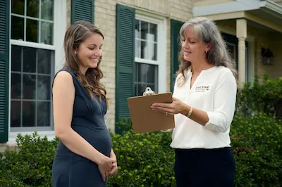 A female FSP technician speaking with a female client about painting services outside the home.