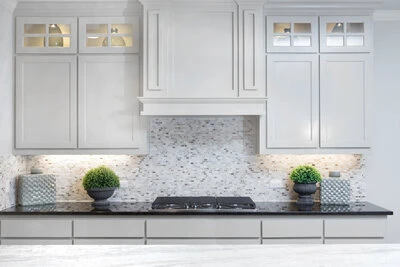 Beautiful white cabinets above a black counter and cooktop.