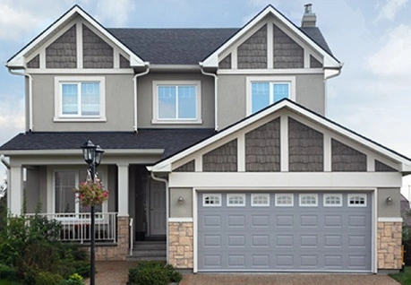 Gray two story residential home with lamppost and large garage.