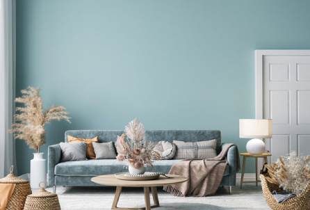 Living room with cyan walls and a blue couch behind a round coffee table.