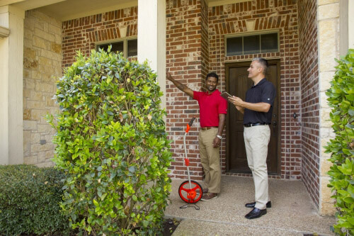 Five Star Painting estimator reviewing brick exterior with homeowner