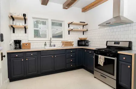 A modern kitchen with black painted cabinets.