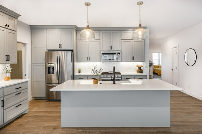 Farm-style kitchen with light gray cabinets and white interiors