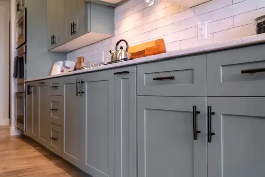 Freshly painted gray kitchen cabinets in modern kitchen.
