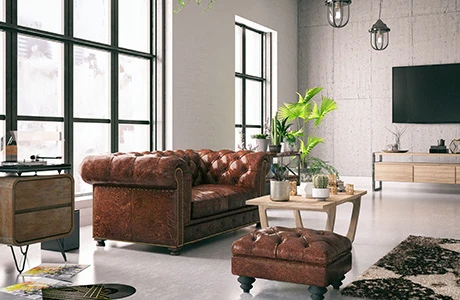 A room with large windows, a brown leather sofa, wood side table and coffee table, and big TV on the wall. 