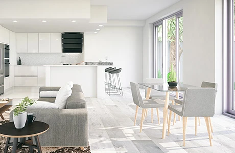 A clean modern apartment with white walls, a kitchen, dining table and sofa.