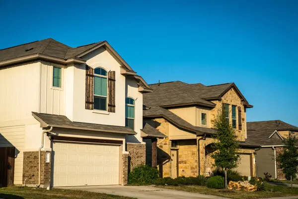 Row of Texas single family residential homes at sunset painted in beige neutral colors.