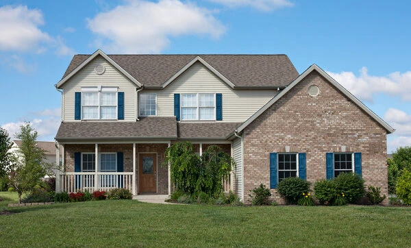 Michigan home exteriors painted tan with blue shutters and white poles and hand rails.