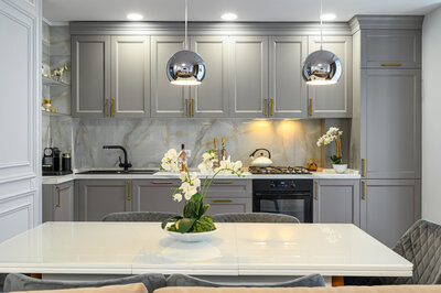 Kitchen with gray cabinets and marble backsplash.