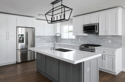 Kitchen with white cabinets, large island  and stainless steel appliances.